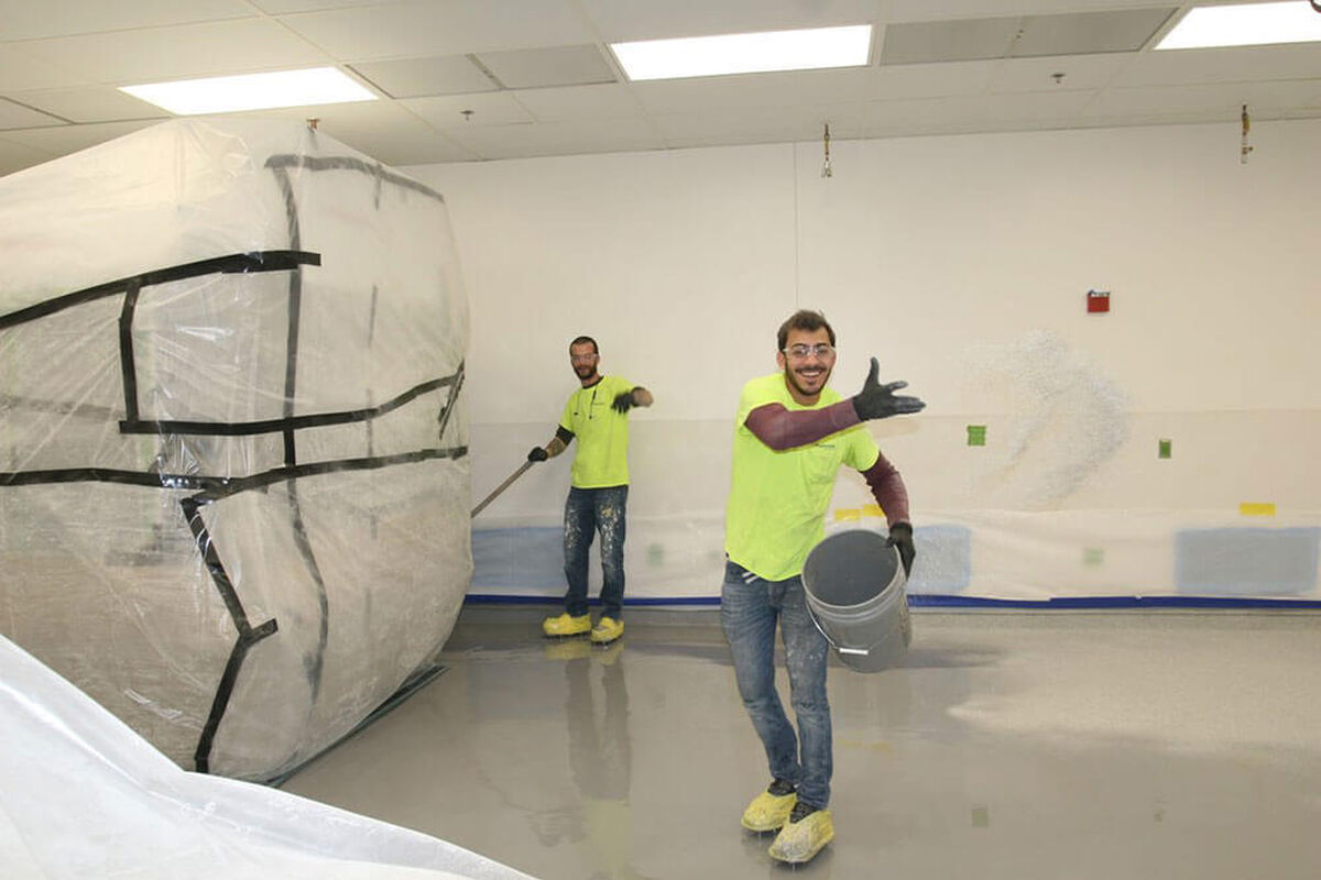 Contractors working on industrial flooring on a polished concrete floor When Is the Best Time to Re-Do My Industrial Flooring?