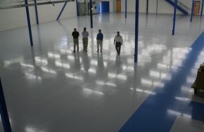 Three men standing on a newly polished floor. Epoxy Floor Coating - Why Do It?